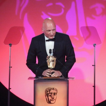 Dan Reed accepts the award for Director: Factual at the British Academy Television Craft Awards in 2015