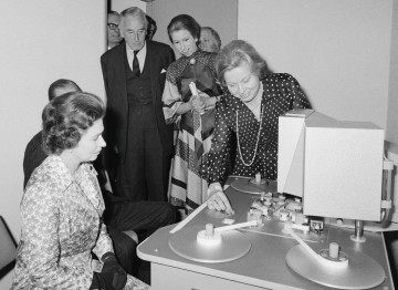 The Queen inspects a steenbeck in one of the viewing rooms at 195 Picadilly at the 1976 opening.