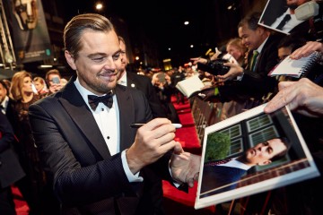 Leonardo DiCaprio signs autographs for fans on the red carpet
