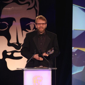 A member of the Hearthstone: Heroes of Warcraft development team accepts the award for Multiplayer at the British Academy Games Awards in 2015