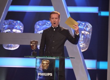 Actor Damien Lewis holds up the winner's envelope for the Supporting Actress category.