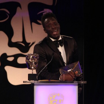 Andy Akinwolere presents the award for Family at the British Academy Games Awards in 2015