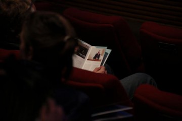 The audience peruse the brochures before the event begins.