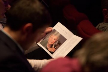 An audience member reads the brochure