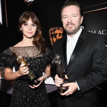 Honorees Felicity Jones and Ricky Gervais pose with their Britannia Awards onstage.