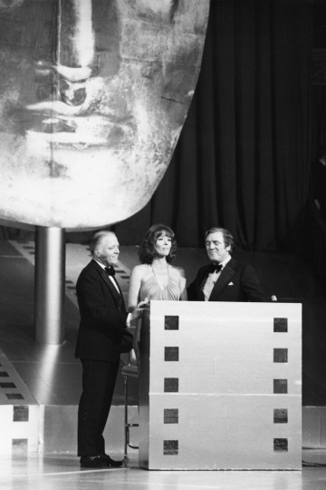 Richard Attenborough on stage with Diana Rigg and Eamonn Andrews at the British Academy Film Awards in 1976.