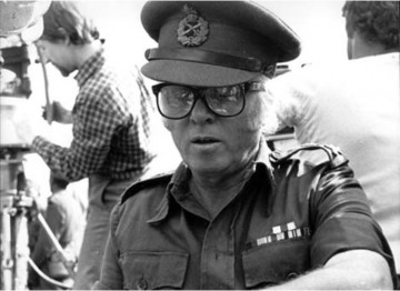 Director Richard Attenborough prepares to film one of the key scenes in New Delhi. So as to keep command of a crowd estimated to number 400,000 he has donned a British Army uniform and will walk behind a re-creation of the Mahatma’s funeral cortege.