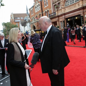 Downton Abbey creator Julian Fellowes being interviewed on the red carpet.