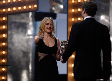 Colin Firth joins Kate Winslet on stage to accept his award for Leading Actor in A Single Man (BAFTA/Brian Ritchie).