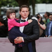 Allen Leech holding his on-screen daughter Fifi Hart on the red carpet at the BAFTA Downton Abbey Tribute event.