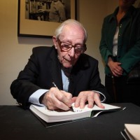 Gilbert signs his memoirs compiled over the course of seven decades working in the film industry.