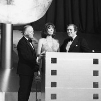 Richard Attenborough on stage with Diana Rigg and Eamonn Andrews at the British Academy Film Awards in 1975.