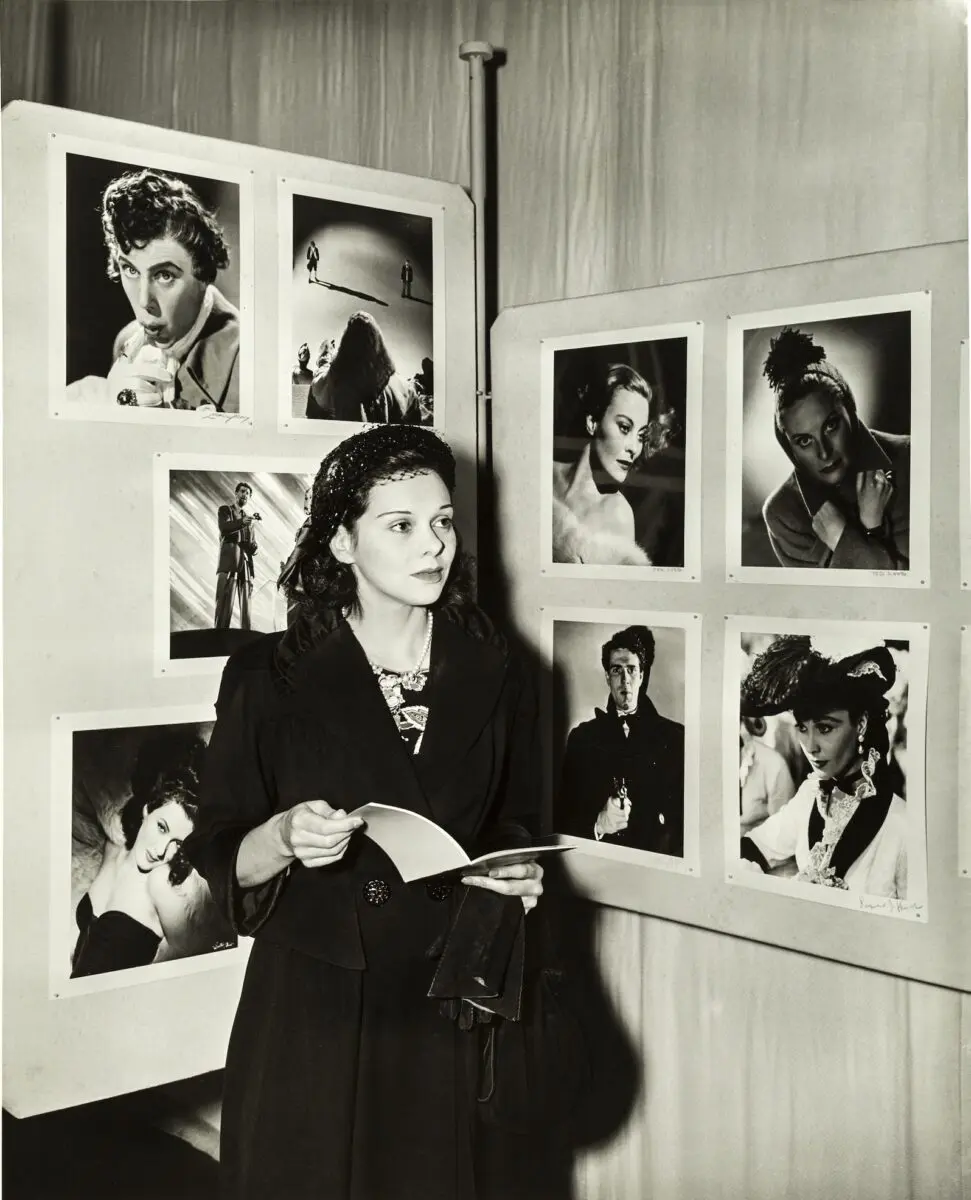 A woman wearing a black coat holding a booklet