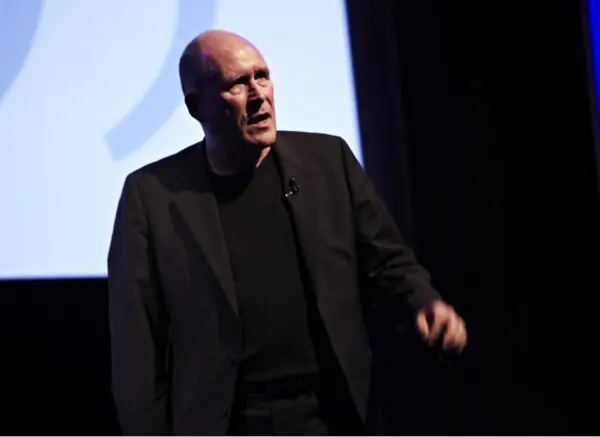 A bald man wearing a black suit.