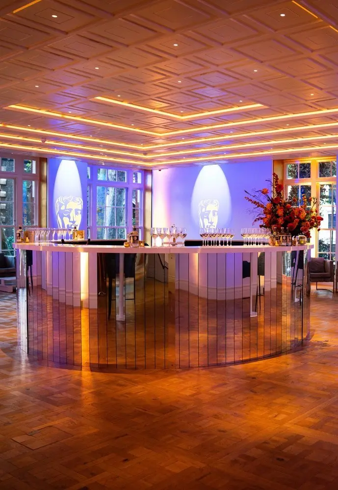 The Ray Dolby Room. A large round mirrored bar in the middle of room with high ceilings and projection walls.