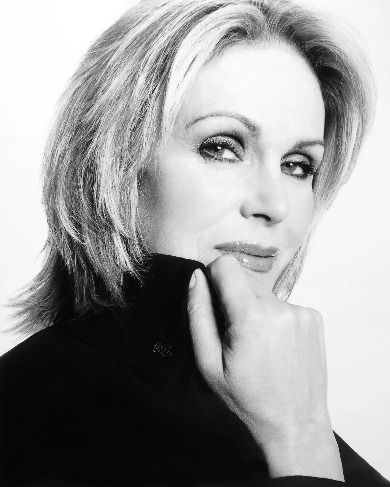 A woman with a blonde bob wearing a black top.