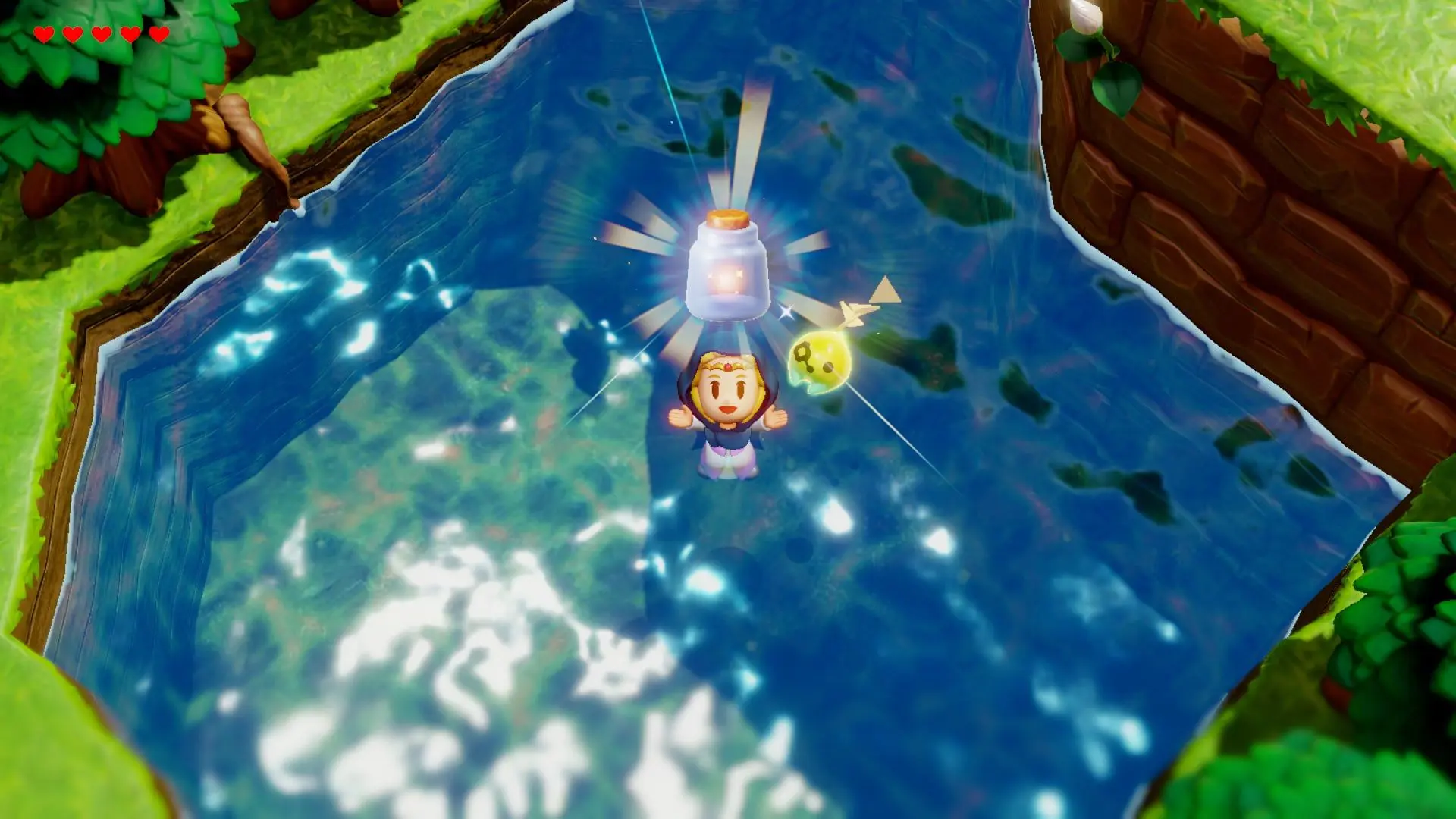 An animated figure wearing a blue hood and with a red gem on their forehead with a glowing jar above their head.