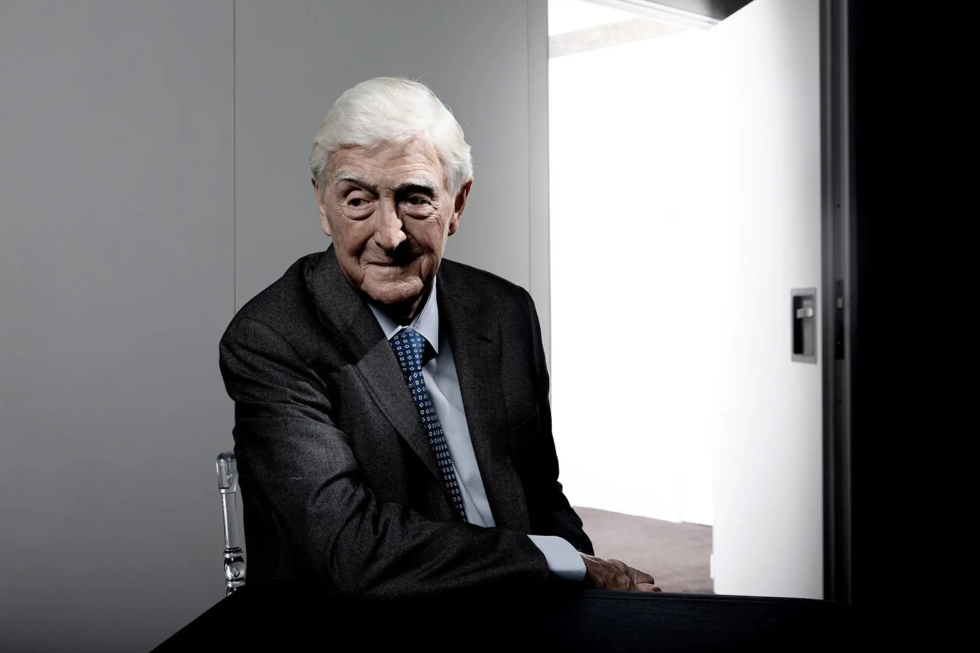 Michael Parkinson. A white man with white hair wearing a dark suit.