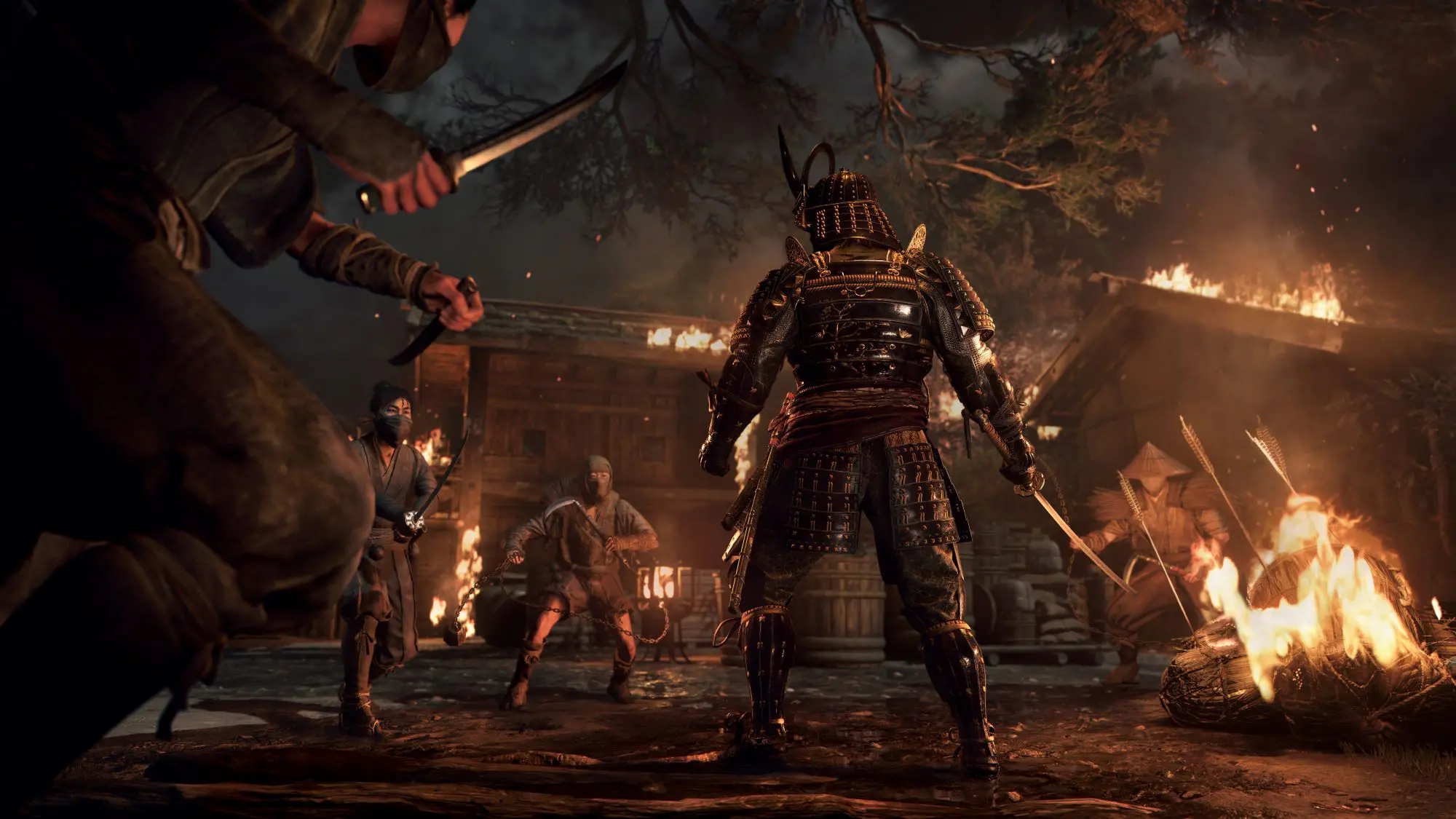 A still from the game Assassin's Creed Shadows. An armoured warrior holding a sword stands in the middle of a group of armed assassins wielding weapons.