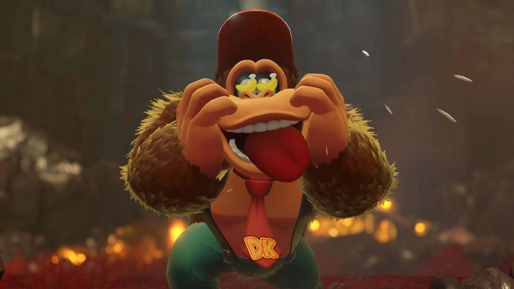 A still from the game Donkey Kong Bananza. A cartoon monkey wearing a tie with DK on it and a red baseball hat. The monkey has cartoon bananas on his eyes.