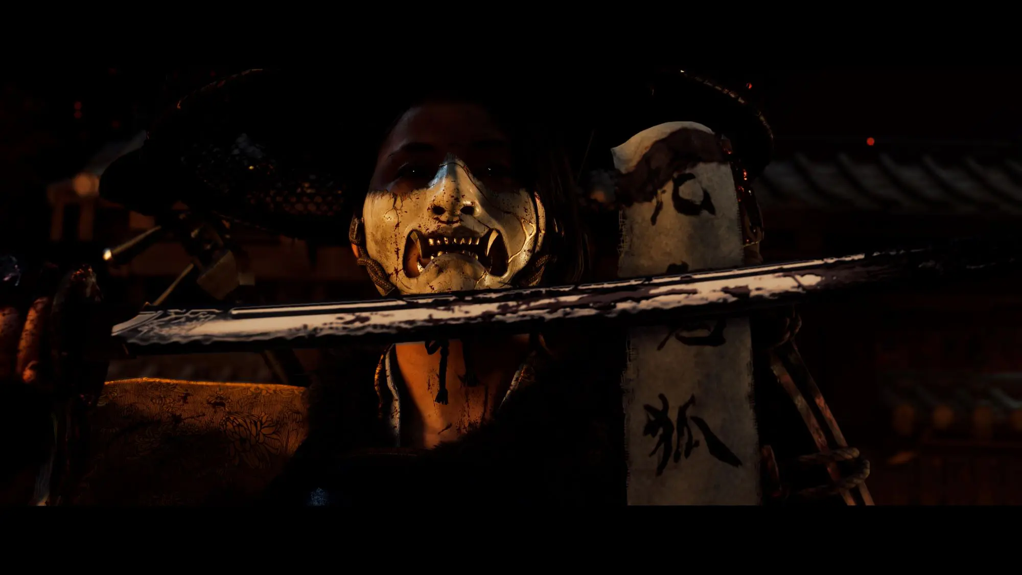 A still from the game Ghost of Yōtei. A person wearing a white facemask and with gold grills in holding a samurai sword in front of their face.